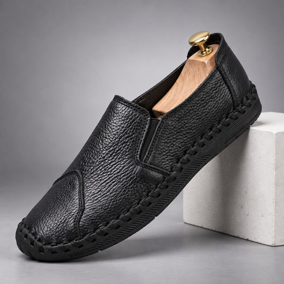 Loafers with a black pebbled body and a black sole. (plinth)