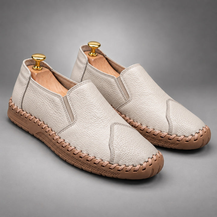 Loafers with a light beige pebbled body and a light brown sole.