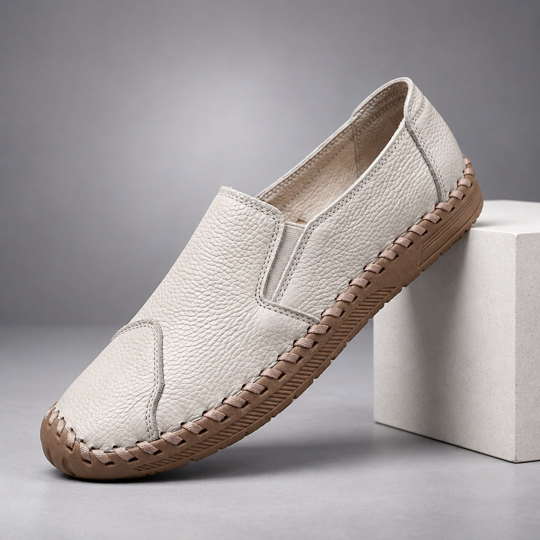 Loafers with a light beige pebbled body and a light brown sole. (plinth)
