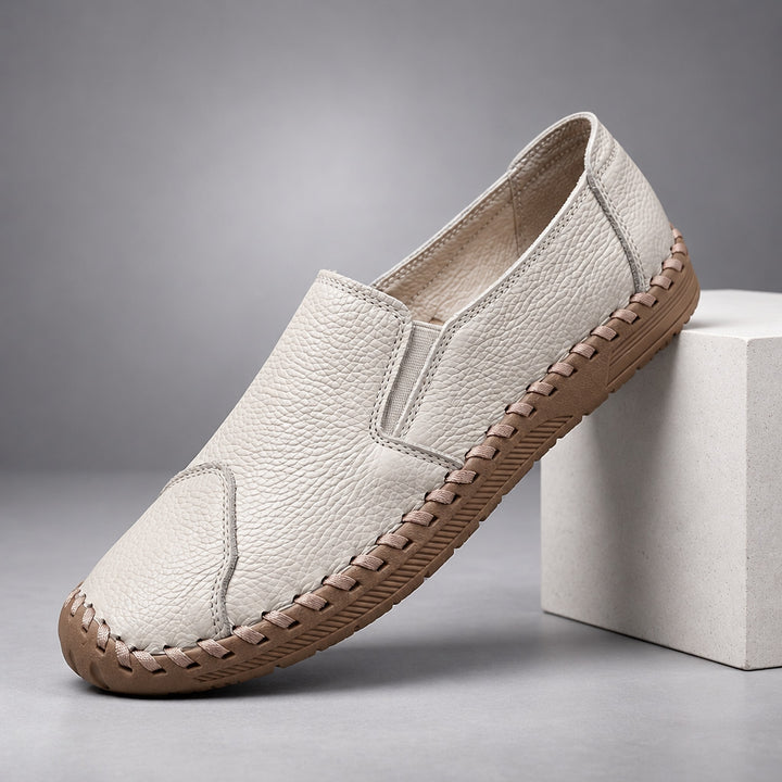 Loafers with a light beige pebbled body and a light brown sole. (plinth)