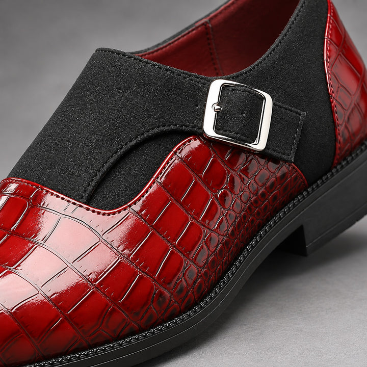 Glossy crocodile pattern burgundy loafers with a silver buckle and black sole. (detail macro)