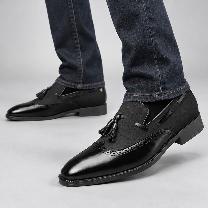 Black shoes with a mix of glossy leather and matte textured fabric, finished with black stitching. (on model)