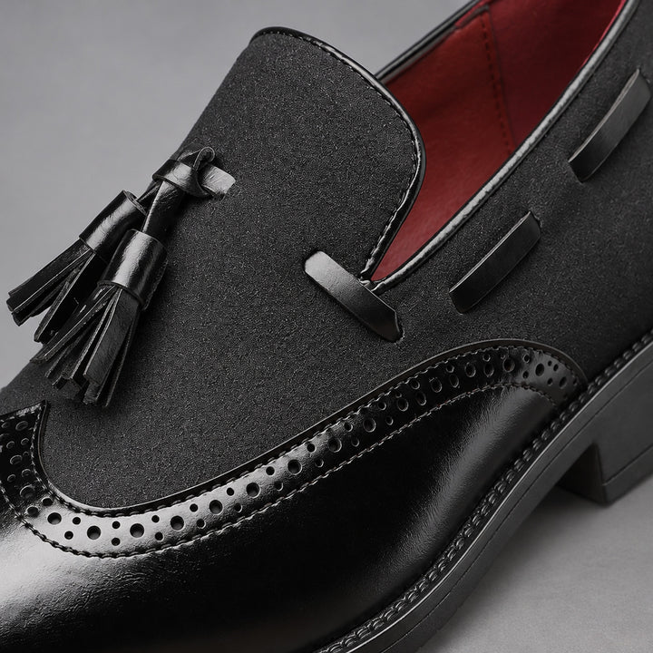 Black shoes with a mix of glossy leather and matte textured fabric, finished with black stitching. (alt macro)