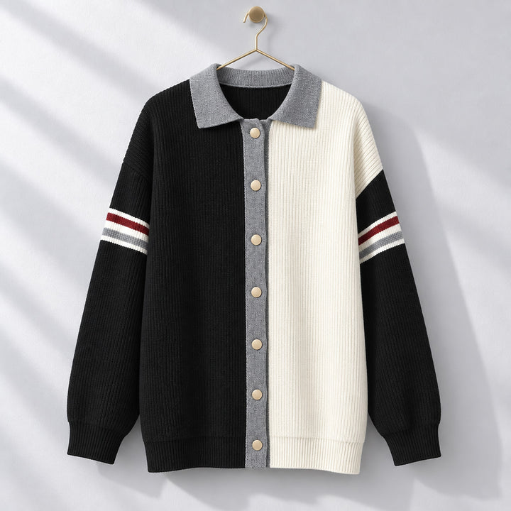 Cardigan sweater with a black left side, cream right side, matte beige buttons, and medium gray trim. (hanging)
