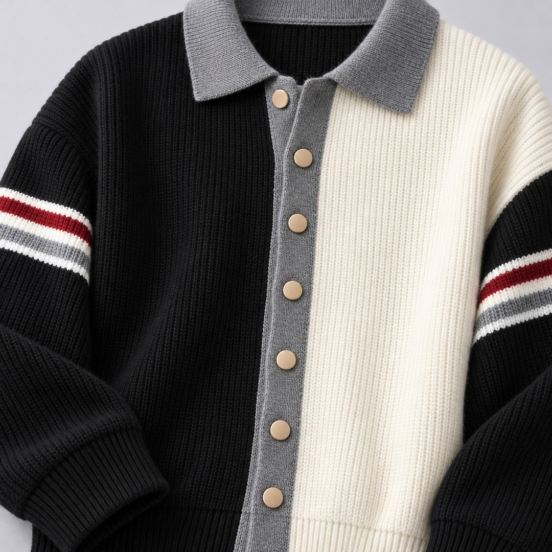 Cardigan sweater with a black left side, cream right side, matte beige buttons, and medium gray trim. (detail macro)