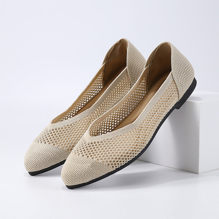 A light beige ballet flat in knitted fabric with a black sole and a matte finish.