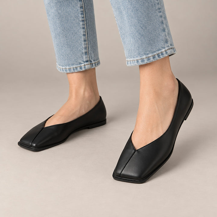 Mirana Leather Flats in Black (on model legs)