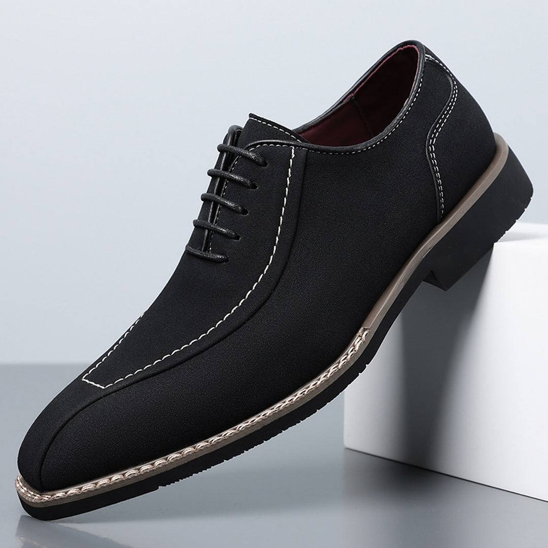 Matte black oxfords with cream stitching and a black sole edged in light brown.