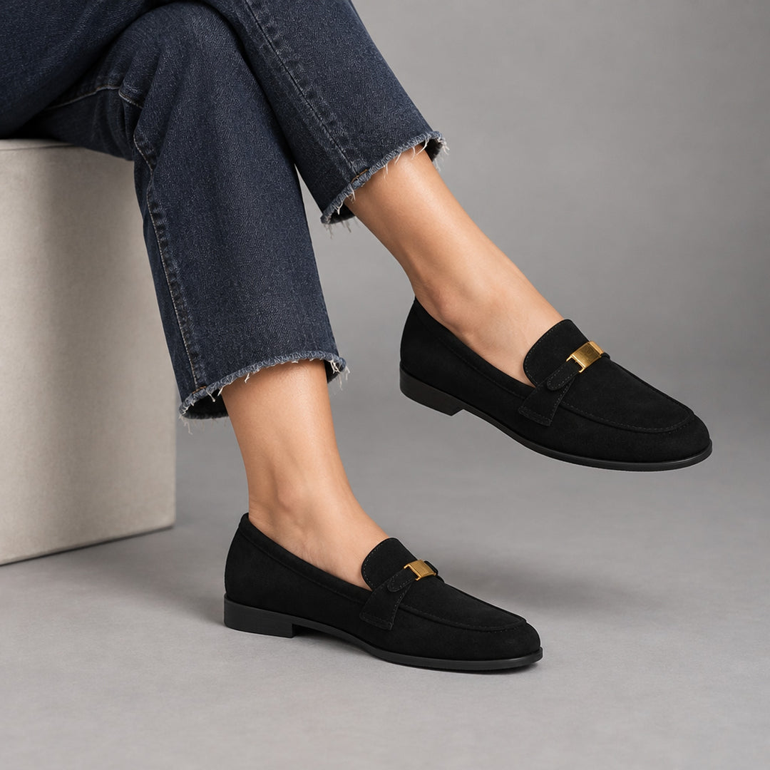 Matte black suede-look loafers with a black sole and gold buckle.